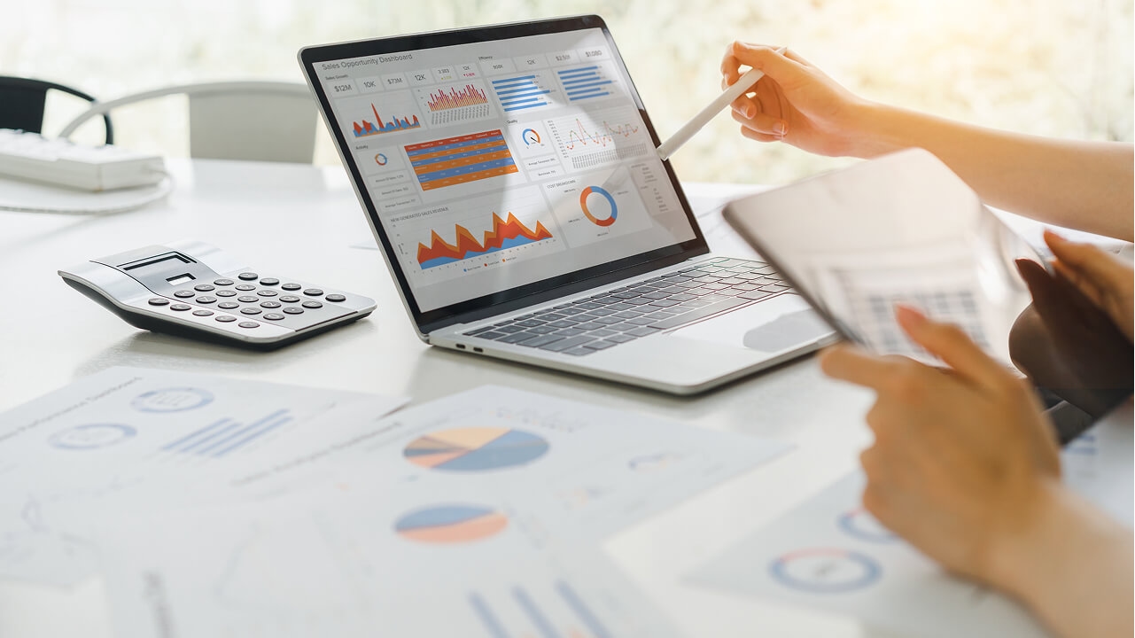 Financial professional analyzing data on a laptop, representing secure financial endpoint compliance.