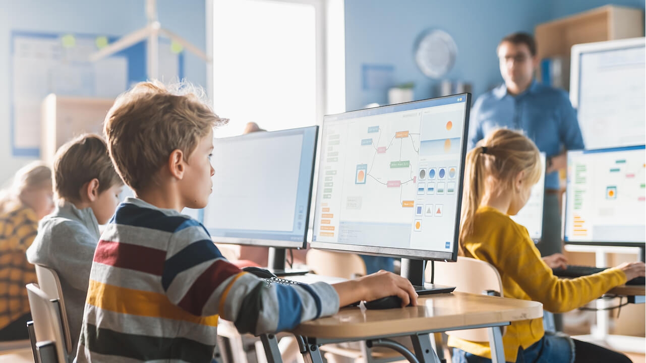 Students working on computers in a modern classroom setting for secure educational learning.